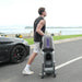 Player wheeling the AceiiLab A1 tennis robot to the court like a suitcase